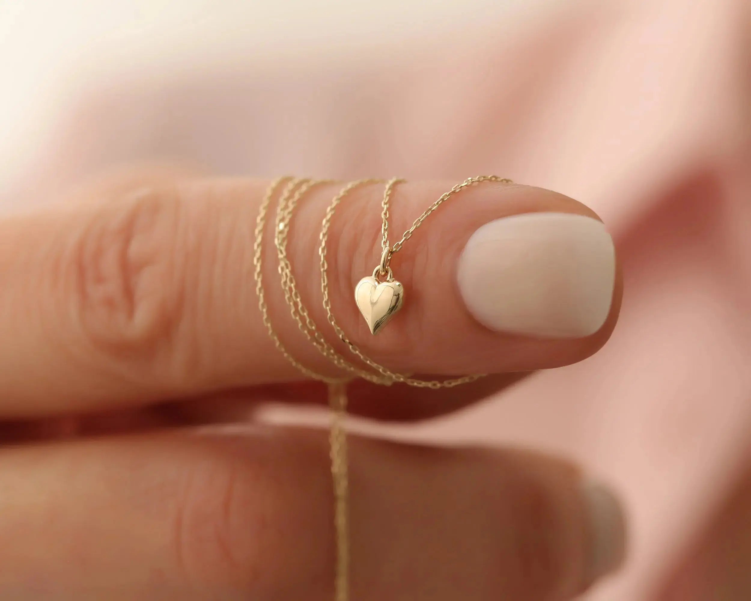lady holding 14K Gold Heart Necklace and Bracelet