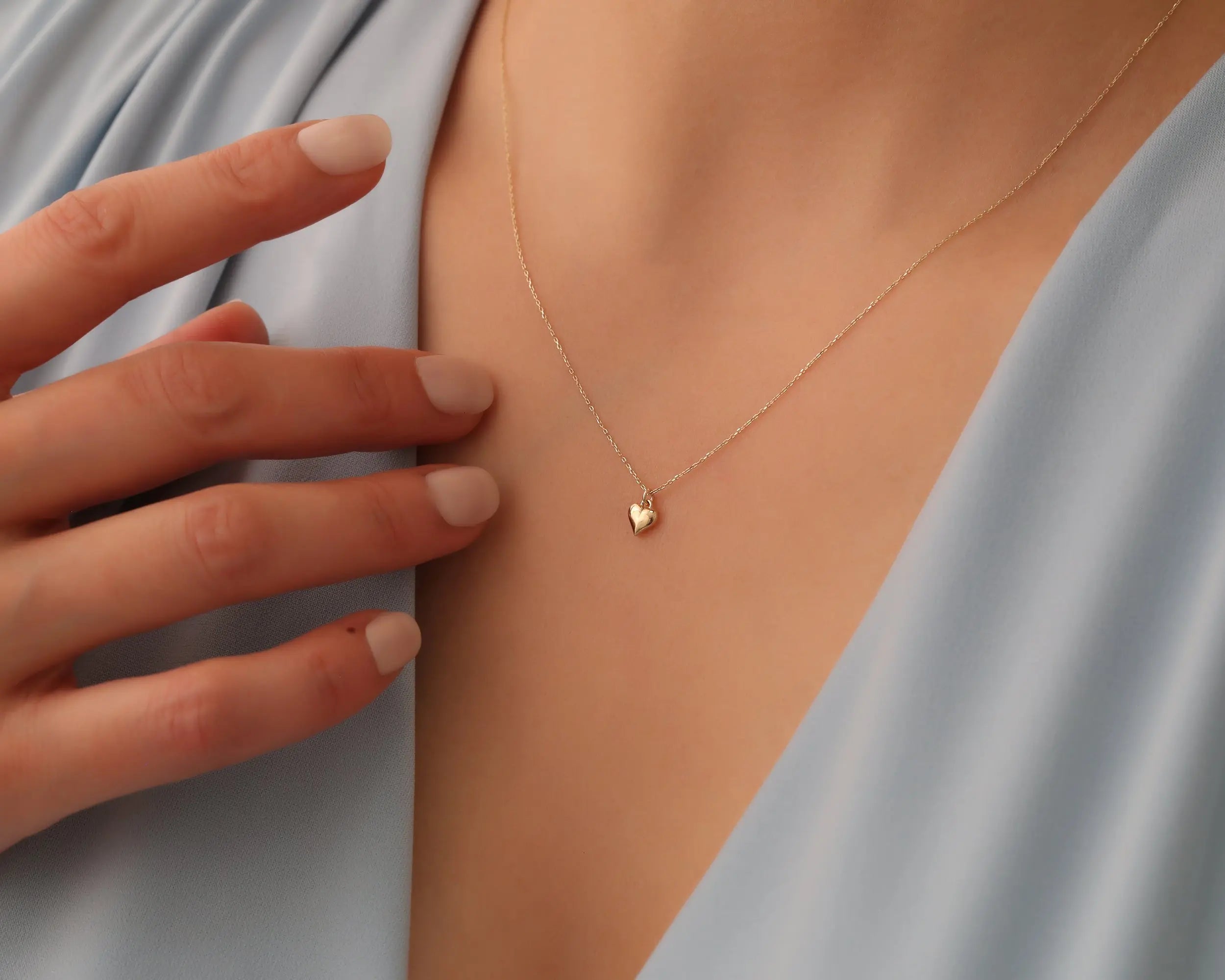 lady holding 14K Gold Heart Necklace and Bracelet