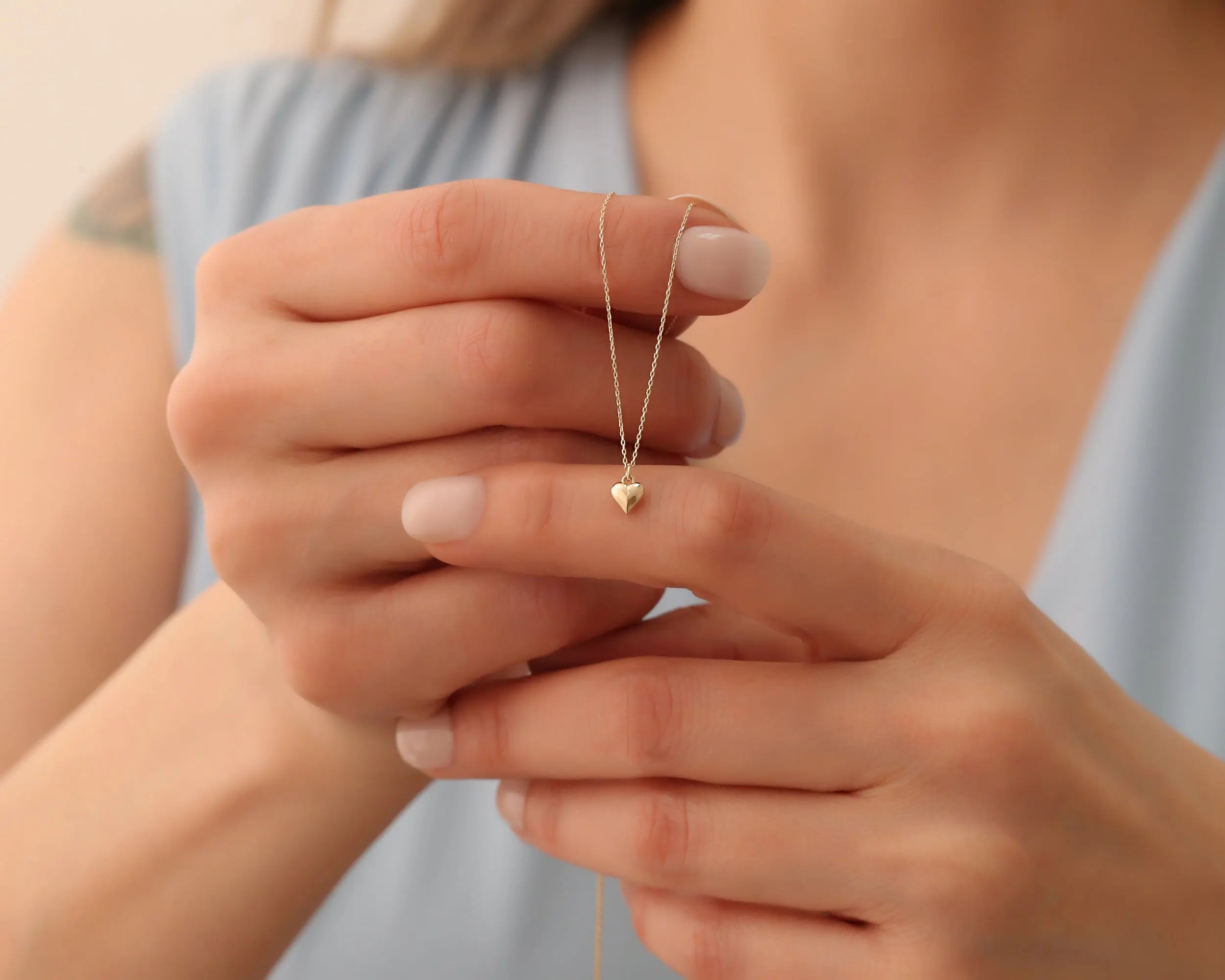 lady holding 14K Gold Heart Necklace and Bracelet
