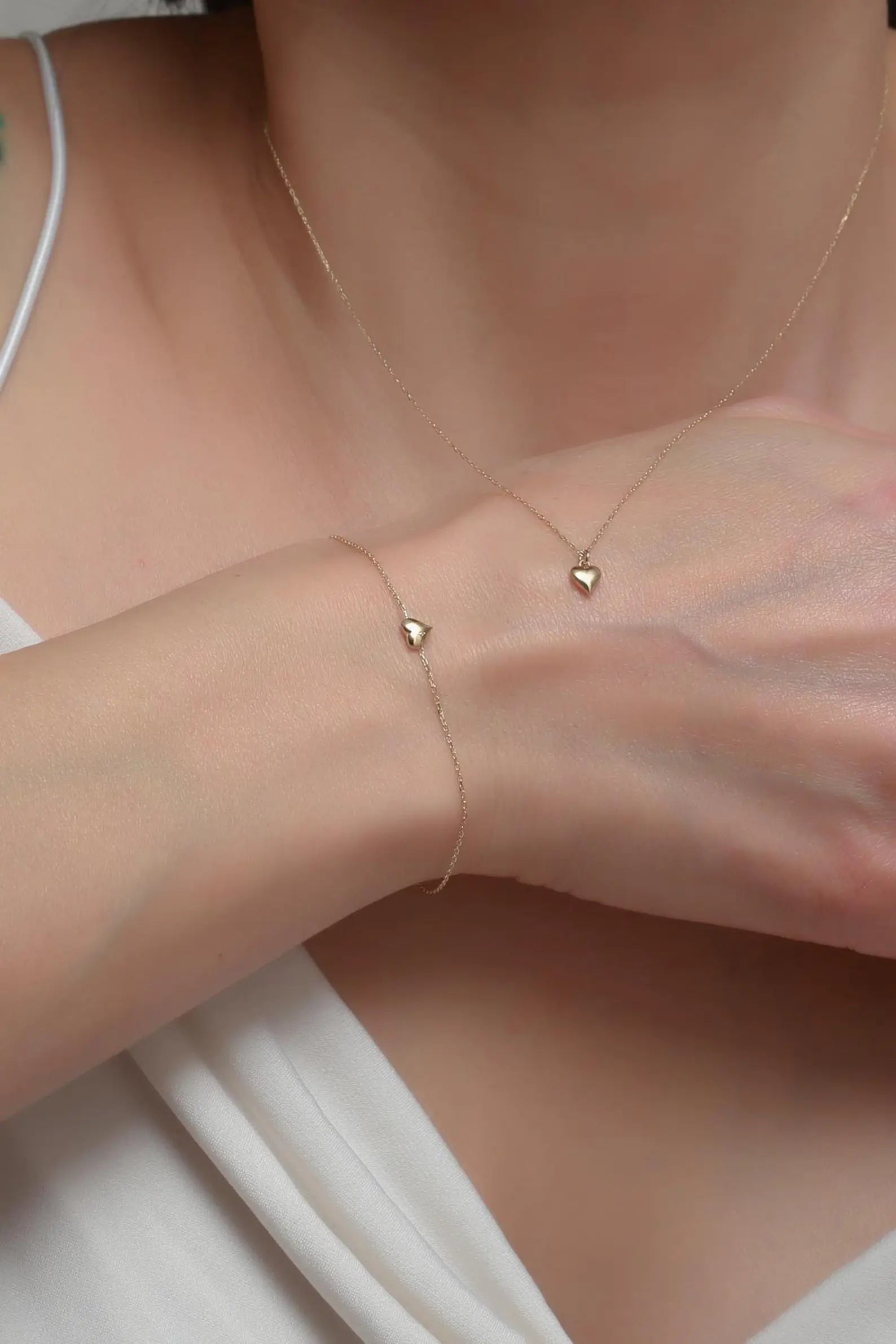 a young lady wearing 14K Gold Heart Necklace and Bracelet