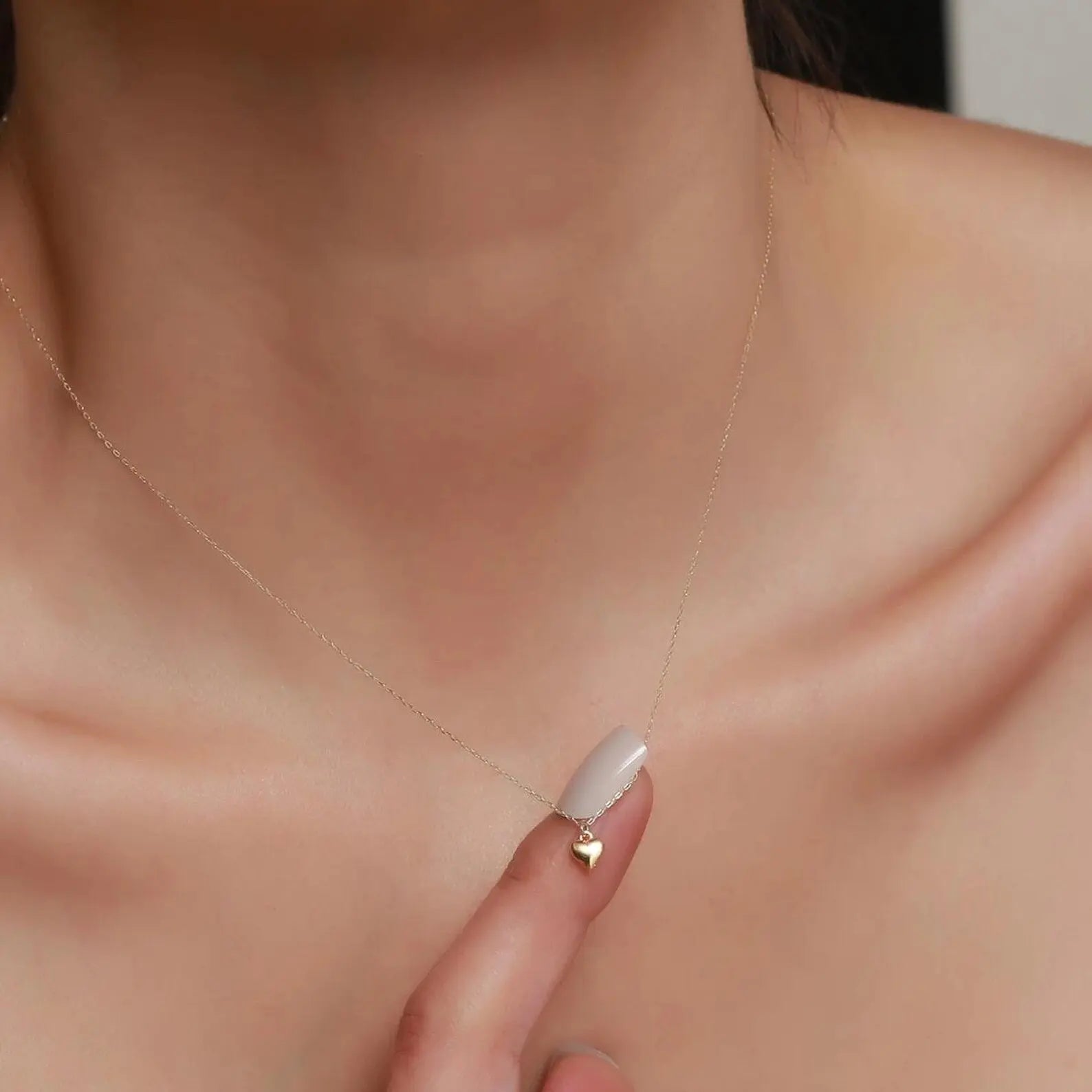 lady holding 14K Gold Heart Necklace and Bracelet